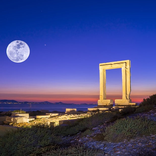 Entrance ruins of the Apollo Temple and the illuminated Portara Gate during a Naxos Island sunset in Greece Dolomites with Bruno Pisani & Luka Vunduk - Culinary and Wellness - JOURNEY - Zhoola