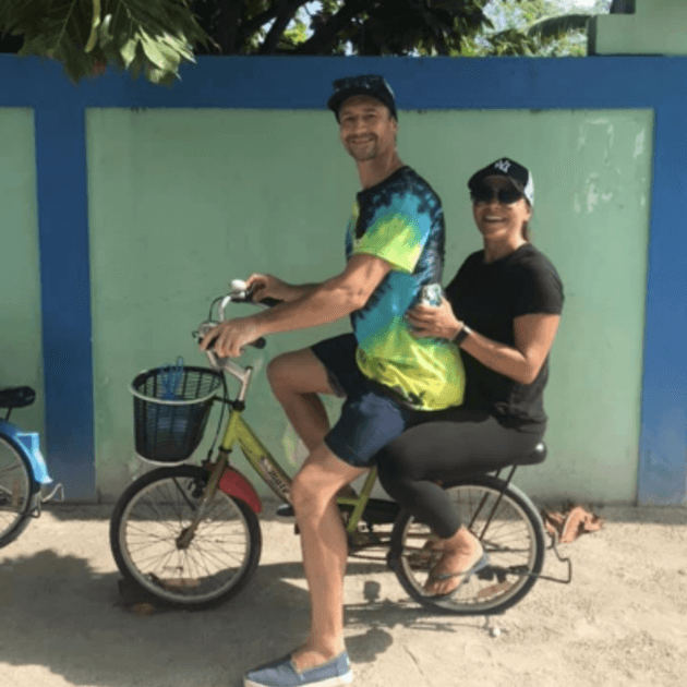 Load image into Gallery viewer, A cheerful couple enjoying a bike ride together - Maldives SUP surf trip with Tiago Silva - Live Aboard Surfing - Zhoola
