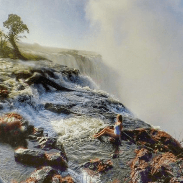 Load image into Gallery viewer, Girl sitting on Edge of Water fall - Safari &amp; Waterfalls in Africa with Alyssa Ramos - Safari &amp; Culture (women only) - JOURNEY
