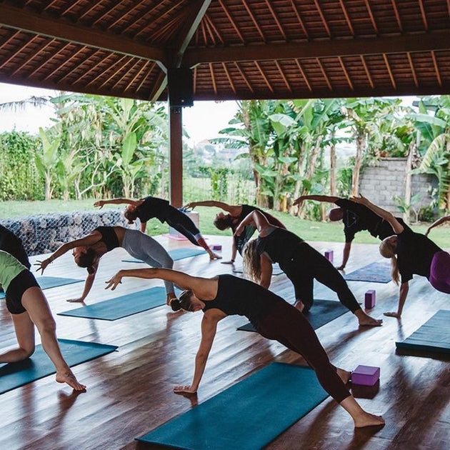 Practicing the low lunge yoga pose in a serene yoga shala.Signature India with Sandhya Balakrishnan - Yoga & Exploration - Journey - Zhoola